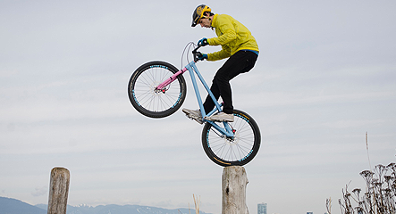 Photo of a mountain biker balancing on a post